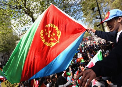 LONDON, ENGLAND - APRIL 30: An Eritrean demonstrator waves his national flag whist taking part in a demonstration on Whitehall on April 30, 2012 in London, England. The protesters were demanding that Britain stops selling arms to Ethiopia, their neighboring country, and for Ethiopian nationals to leave Eritrea. (Photo by Dan Kitwood/Getty Images)